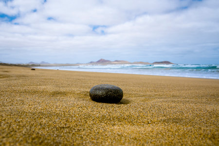 Empty beach with black stone in the foregroundの写真素材