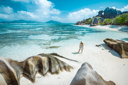 A young girl standing in shallow water on La Digue island, Seychellesの写真素材