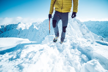A climber ascending a mountain in winterの写真素材
