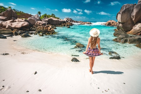 A young girl standing in shallow water on La Digue island, Seychellesの写真素材