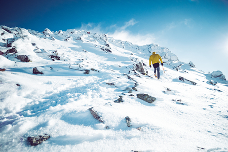 A climber ascending a mountain in winterの写真素材