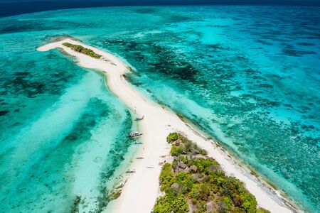 Truly amazing tropical island in the middle of the ocean. Aerial view of an island with white sand beaches and beautiful lagoonsの写真素材