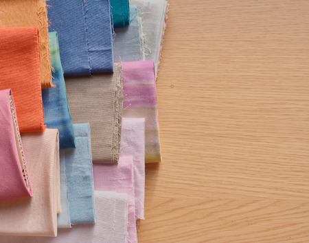 Rolls of textile, cloth and tissue of various colours on wood backgroundの写真素材