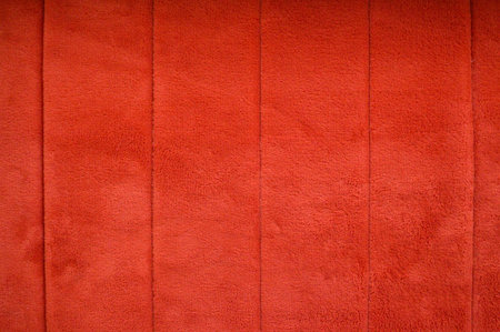 Red texture of fluffy carpet with vertical stripes, background.の写真素材