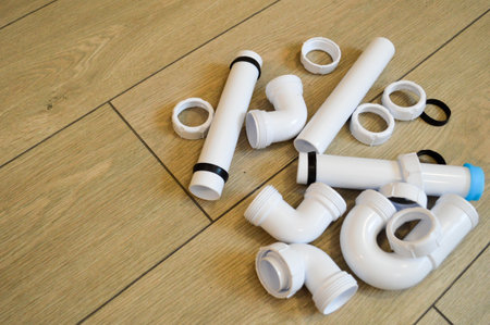 White plastic plumbing, plumbing pipes, smooth and curved, fittings, flanges, rubber gaskets.