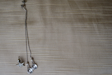 Silver earrings with diamonds, precious stones, rhinestones on a beige background.の写真素材