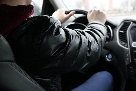 Hands of a man on the steering wheel of a car. Male driver driving a car.の写真素材