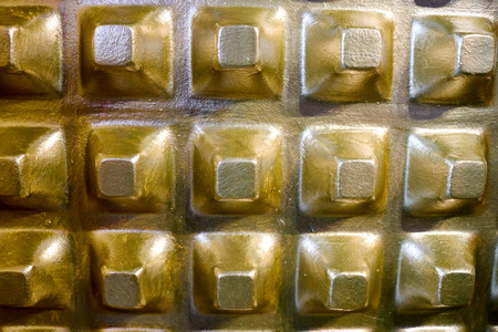 Golden, shiny, yellow volumetric, convex pyramids, squares, rectangles on the wall. The background. Texture.  Backdrop.の写真素材