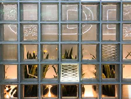 The texture of a beautiful glass carved glowing transparent square square of small decorative tiles...