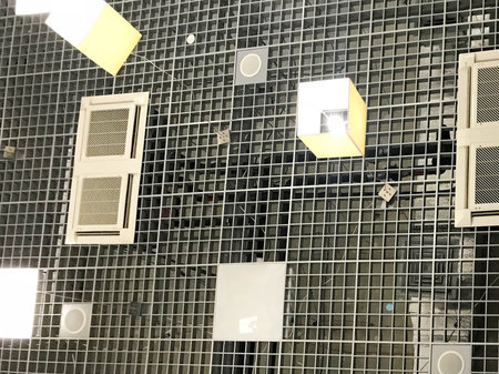The texture of the industrial ceiling in the building with a metal grille and ventilation of lamps,...