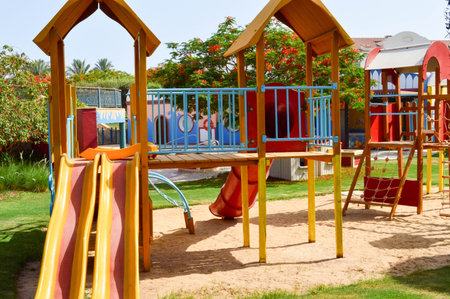 A cheerful children's playground with slides of sand puddles playing games and designs in an exotic...