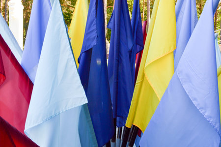 Texture of multi-colored festive red, blue, yellow flags made of fabric. The background.