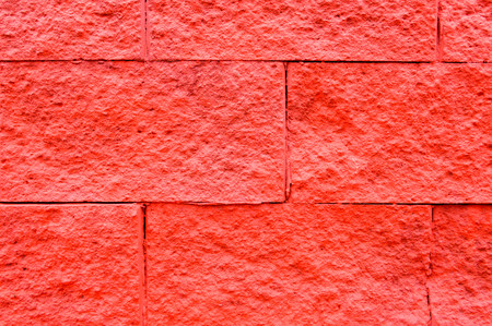 Texture of bright red large large rectangular convex stone bricks.の写真素材
