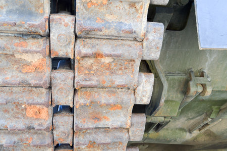 Rusty iron dirty metal heavy track caterpillar of a large green military off-road armored deadly...