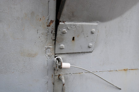 The texture of the blue broken out bent hacked iron metal door with a lock from a homemade crafty...