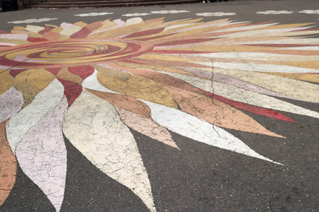 Texture pattern in the shape of a flower with petals of colorful beautiful on the road asphalt. The...