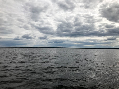 Landscape of the nature of the horizon line with a view of the shore, water with waves from the middle of the lake in the cold cloudy weather.の写真素材
