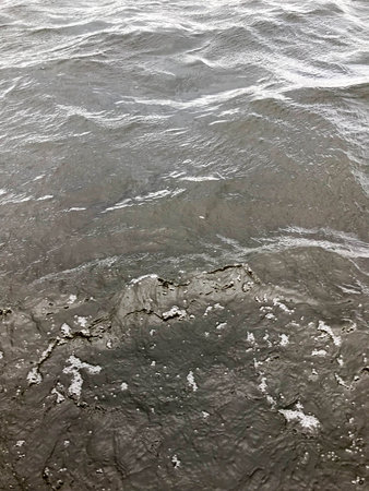 Texture of dark black cold water with waves of ripples rippling. The background.の写真素材