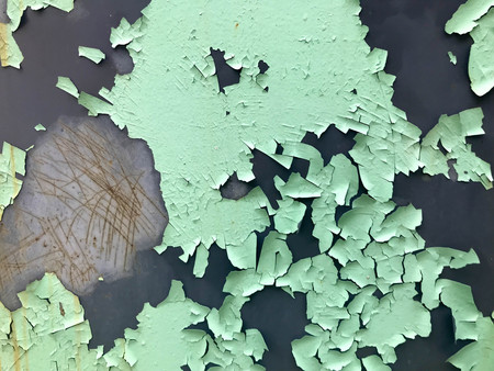 The texture of the old shabby turquoise light green peeling paint with cracks and scratches on the rusty metal wall. background.の写真素材