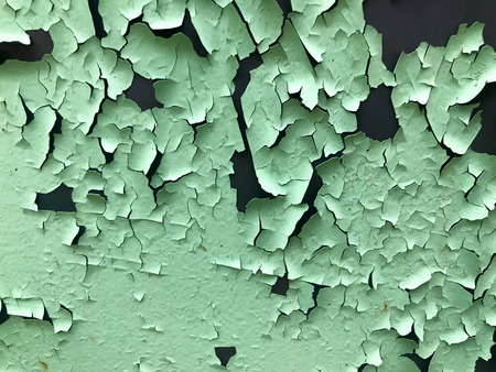 The texture of the old shabby turquoise light green peeling paint with cracks and scratches on the rusty metal wall. background.の写真素材