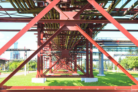 Red metal structures, wheel supports for pipes, pipeline trestle from large beams, piles and...