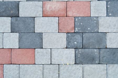 Texture of gray rectangular concrete stone paving slabs on the road with seams. The background.
