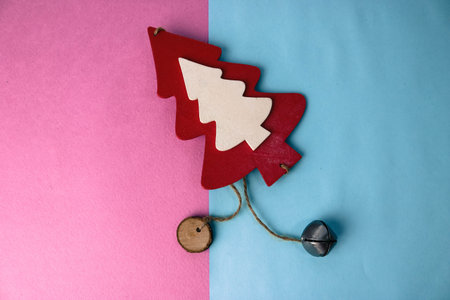 Festive New Year's Christmas beautiful bright multi-colored joyful blue and pink background with a small toy wooden red and white cute Christmas tree. Flat lay. Top view. Holiday decorations.の写真素材