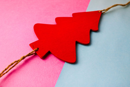 Festive New Year's Christmas beautiful bright multi-colored joyful blue and pink background with a small toy wooden red and white cute Christmas tree. Flat lay. Top view. Holiday decorations.の写真素材