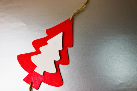 Festive Christmas Christmas winter happy beautiful gray silver shiny background with a small toy wooden homemade cute Christmas tree. Flat lay. Top view. Holiday decorations.の写真素材
