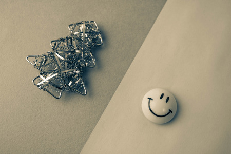 Festive Christmas Happy Sepia Christmas joyful background with a small toy metal iron homemade Christmas tree and a smiling yellow jolly emoticon. Flat lay. Top view. Holiday decorations.の写真素材