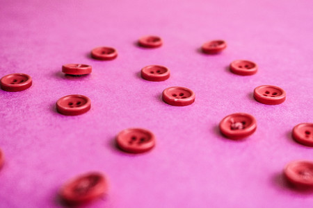 Beautiful texture with many round pink buttons for sewing, needlework. Copy space. Flat lay. Pink, purple background.の写真素材