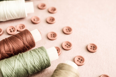 Beautiful texture with lots of round red buttons for sewing, needlework and skeins of spools of thread. Copy space. Flat lay. Pink, purple background.の写真素材