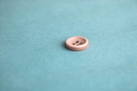 Beautiful texture with a round white button for sewing, needlework. Copy space. Flat lay. Blue...