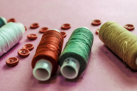 Beautiful texture with lots of round red buttons for sewing, needlework and skeins of spools of...