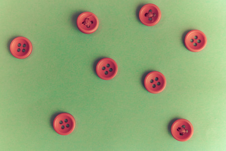 Beautiful texture with many round red buttons for sewing, needlework. Copy space. Flat lay. Green background.の写真素材