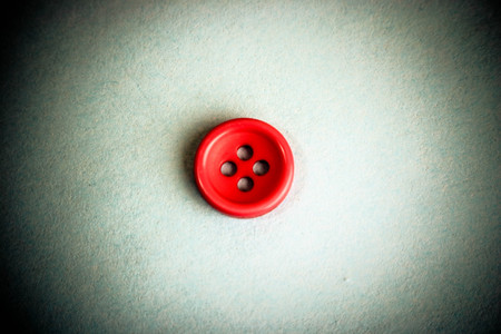 Beautiful texture with a round button for sewing, needlework. Copy space. Flat lay. Blue background.の写真素材