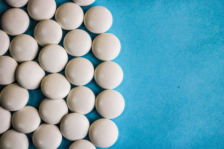 Beautiful texture with white round smooth medical pills, vitamins, antibiotics and copy space on a...