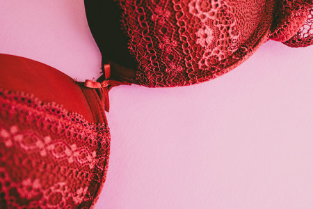 Beautiful red lace female secular gentle bra, underwear and copy space on a pink, purple background. Flat lay.の写真素材