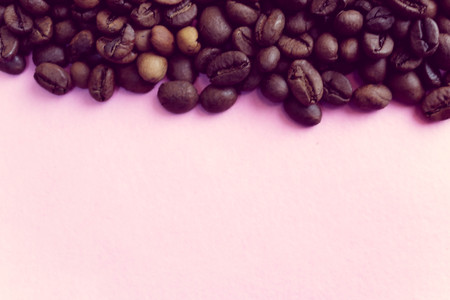 Beautiful texture of freshly roasted selected delicious rich brown natural fragrant coffee tree grains, Arabica coffee beans, Robusta. Flat lay and copy space on pink purple background.の写真素材