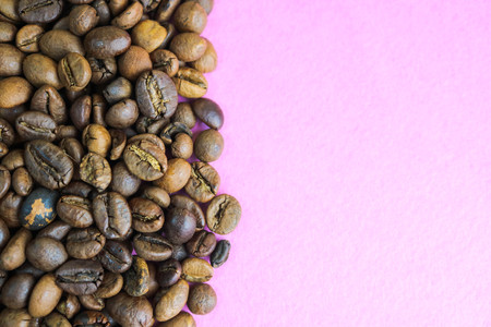 Beautiful texture of freshly roasted selected delicious rich brown natural fragrant coffee tree grains, Arabica coffee beans, Robusta. Flat lay and copy space on pink purple background.の写真素材