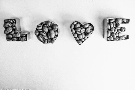 Beautiful texture with the word love for valentine's day inscription made from roasted selected brown natural aromatic Arabica coffee beans, robusta Copy space, flat lay, black and white background.の写真素材