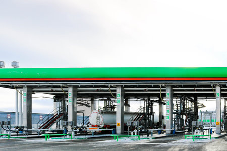 Large green industrial gas station for refueling vehicles, trucks and tanks with fuel, gasoline and diesel in the winter.の写真素材