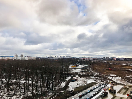 The view from the window of the old city cemetery in the park from a height with trees and houses in the winter. Panorama of the city.の写真素材
