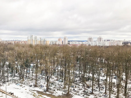 The view from the window of the old city cemetery in the park from a height with trees and houses in...