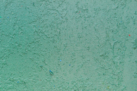 Texture of iron metal painted bright green peeling paint of old battered scratched cracked ancient...
