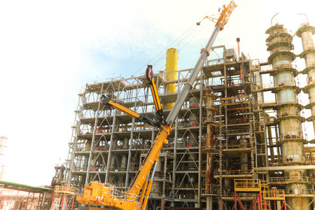 Construction and installation work with a powerful construction crane of a large new industrial oil...