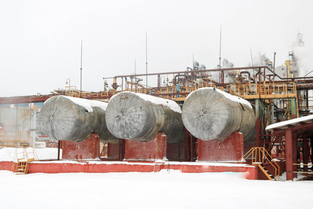 Large iron tanks, ladders and protective fencing pipes equipment and machine tools valves heat...