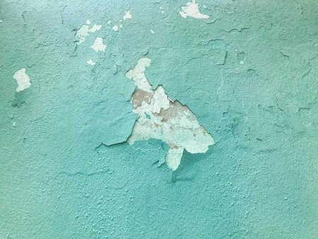 The blue old shabby cracked wall is ancient beautiful with peeling paint. Texture. The background.