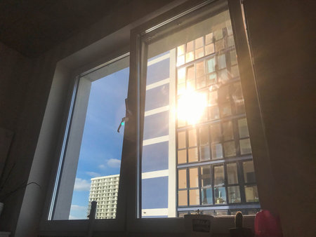 A bright light flare ray of sun shines through the window of the apartment.