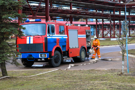 Firemen rescue workers in fireproof suits came to extinguish a fire in a fire truck and stretch the...